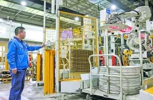 圖：工作人員在5G全連接工廠的成型區(qū)內(nèi)操作機(jī)械手